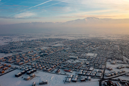 Aerial view of the city in winter with snow covered roofs and houses