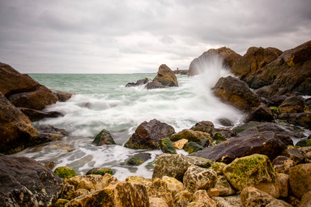 Stormy sea with waves crashing on the rocks on a cloudy day