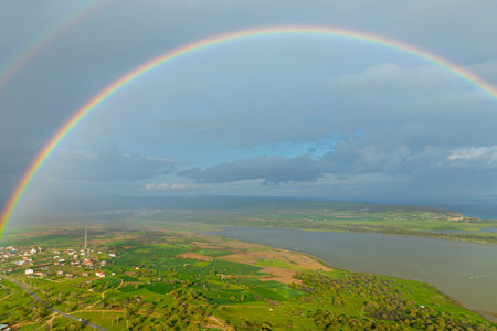 Aerial view of beautiful rainbow over the sea and meadow.の写真素材