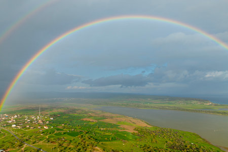 Rainbow over the sea and the villageの写真素材