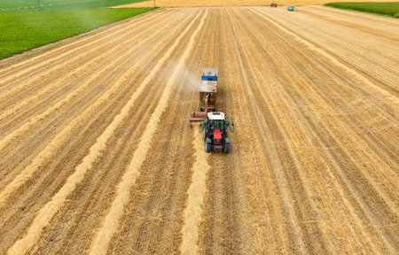Aerial view on the tractor working on the large wheat field.の写真素材