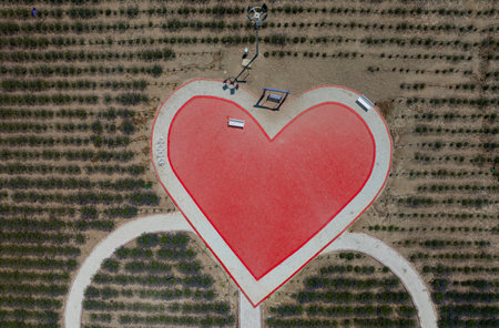 Aerial view of a red heart on the road in the countrysideの写真素材