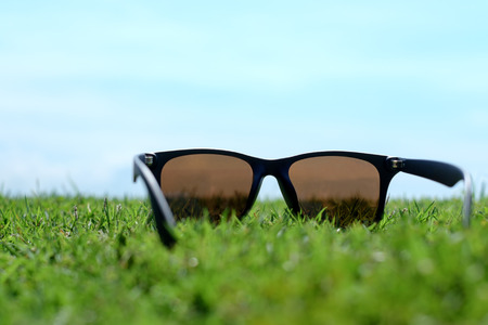 Sunglass on the grass and open sky, travel conceptual backgroundの写真素材