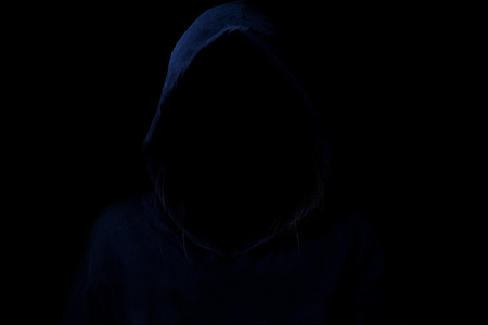 Mysterious, Low light image of Hacker. Unrecognizable person in the hood.の写真素材