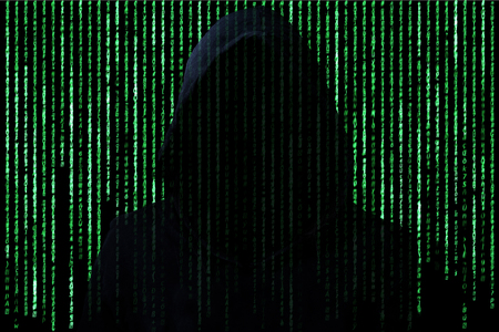 Hacker concept. Unrecognizable person in the hood break computer character codes.Green text on black...