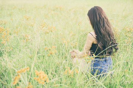 Lifestyle and happiness concept; Happy asian girl sitting on a grass fields.の写真素材