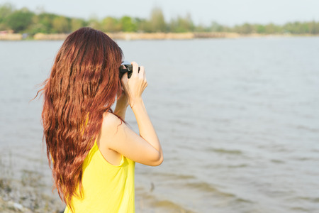 Young asian woman photographer tourist girl posing outdoor with retro camera.の写真素材