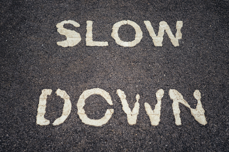 SLOW DOWN print on asphalt road.の写真素材