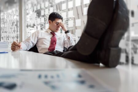 Depressed businessman feeling stressed in office.の写真素材
