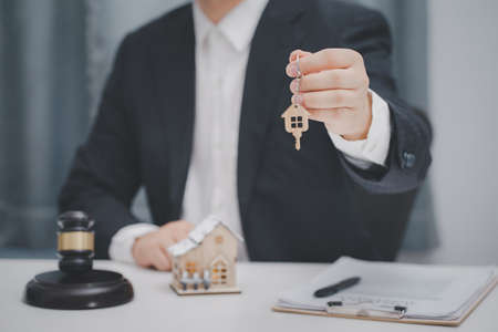 Male lawyer or judge delivering keys to customer. Real estate law and house auction concept.の写真素材