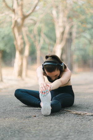 The concept of sport and recreation is depicted in an image of a woman donning sportswear, stretching her leg.の写真素材