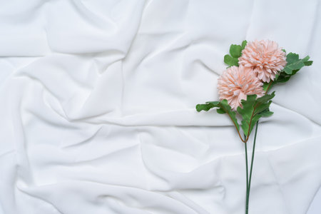 Cherry blossom color flower on white wrinkled, rippled, surface fabric texture background.の写真素材