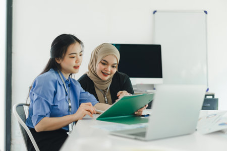 Young diverse people discuss and analyze financial data and marketing strategies, presenting and brainstorming to increase company profitsの写真素材