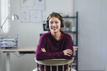 Young woman enjoying music with headphones in a brightly lit roomの写真素材