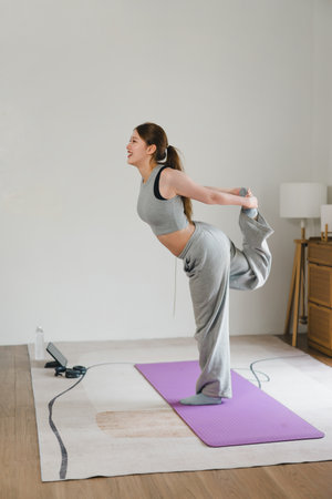 Asian young woman doing yoga stretching exercise on mat yoga, fitness exercises. Healthy lifestyle Calmness and relax at home.の写真素材