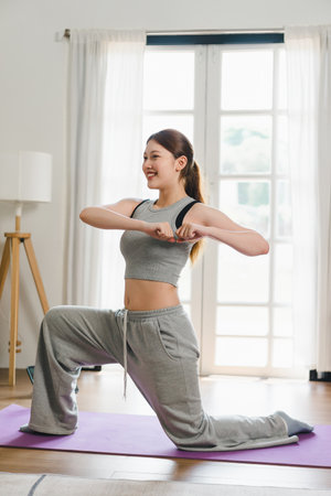 Asian young woman doing yoga stretching exercise on mat yoga, fitness exercises. Healthy lifestyle Calmness and relax at home.の写真素材