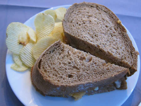 Heart-shaped wholemeal sandwich served with crisps. 