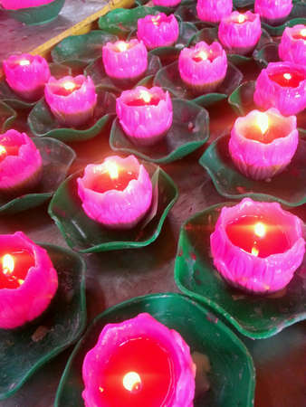 Lotus shaped candles offering in a Buddhist temple.の素材