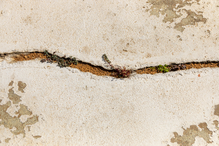 A close up view of a crack in the concreat floor on the outside of a buildingの写真素材