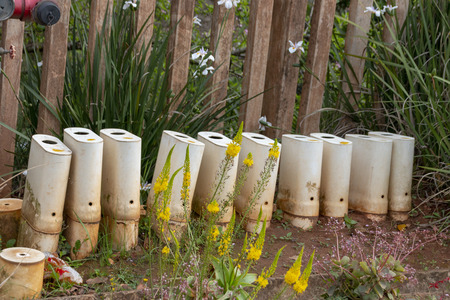 A close up view of ten water meters in a row next to the roadの写真素材
