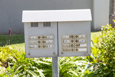 A close up view of a metal intercom outside a block of flatsの写真素材