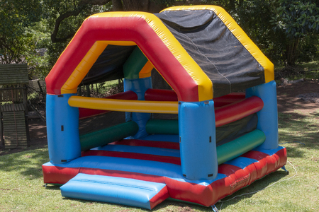 A Close up view of a very colourful blown up jumping castle in the back gardenの写真素材