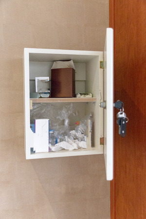 A close up view of a open medicine cabnet in a hospital room with the patients medication in ready to be administratedの写真素材