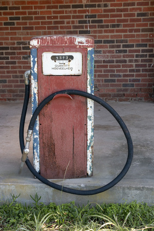 A close up view front of a old white, blue, red and black antique unused petrol pump used for showの写真素材