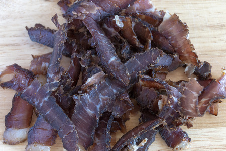 A close up view of a pile of south african biltong on a wood cutting boardの写真素材