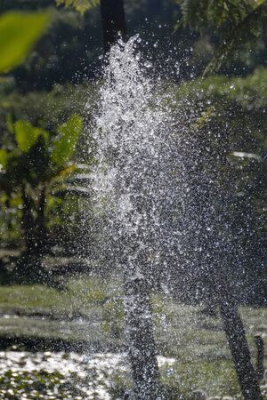 A close up view of a water fountain spraying up into the air on a beautiful summers day.