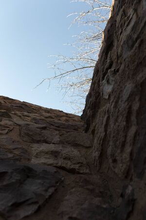 A close up view of the sky from the bottom of a stone wallの写真素材