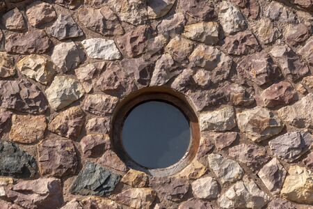A close up view of a round glass window in the front stone buildingの写真素材