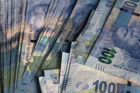 A close up view of fifty rand south african notes in a pile on a isolated black backgroundの写真素材