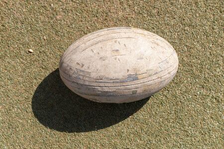 A close up side view of rugby ball on a green grass backgroundの写真素材