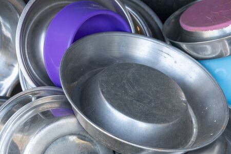 A close up view of metal and plastic dogs bowls all in a pileの写真素材