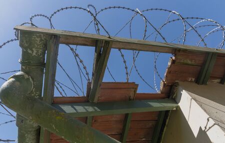A close up view of large metal barbed wire on top of a old buildings roofの写真素材