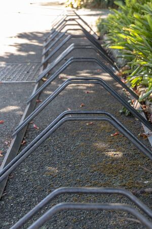 A close up view of a metal bicycle rack on a tar drive wayの写真素材