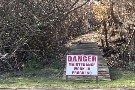 A close up view of a sign that says Danger, no entry zone due to maintenance after a fireの写真素材