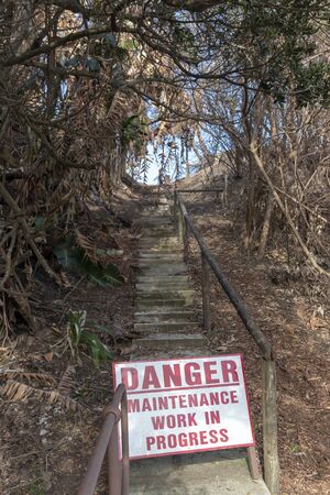 A close up view of a sign that says Danger, no entry zone due to maintenance after a fireの写真素材
