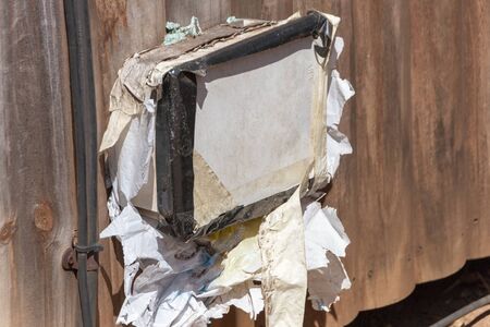 A close up view of an electrical box that has been covered and tape and plastic bagsの写真素材