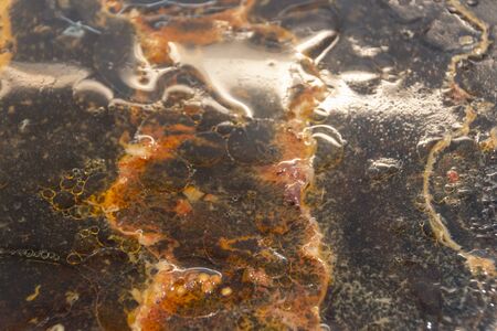 A close up view of a oily cooking tray that has had water added to it to try a help remove the food...