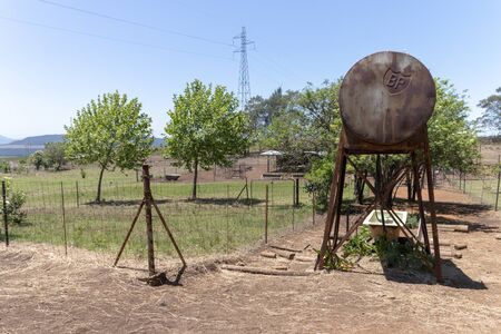 Durban-South Africa, November 2019- A close up view of a old rusted BP metal water tower in an open field on a warm summers day on the farmの写真素材