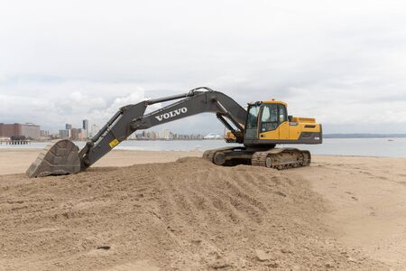 A close up view of a volvo grader digging up sand on Durban beachのeditorial素材