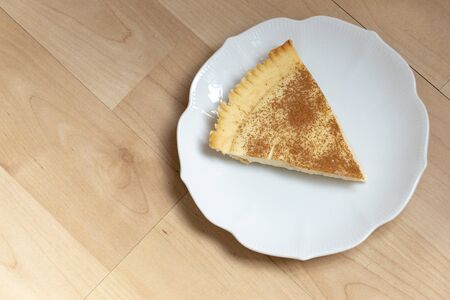 A close up view of a slice of homemade milk tart on a side plate