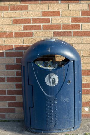 a close up view of a blue public dustbin outisde a supermarket の写真素材