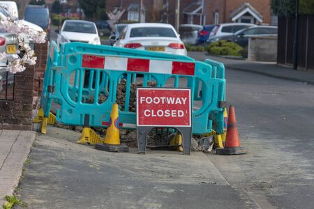 Bristol-March 2020-England-a close up view of a warning sign to say the footway was closed due to renervations and road workers の写真素材