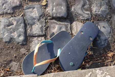 a close up view of a pair of slops that have been left on the side of the roadの写真素材