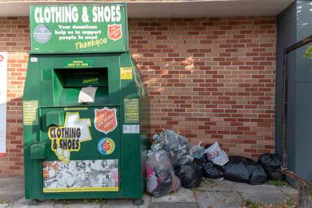 Bristol-March-2020-England-a close up view of a salvation army storage unit for shoes and clothes that has been closed due to the coronavirus COVID-19 epedemic so the clothes ans shoes are left nexrt to the main uintのeditorial素材