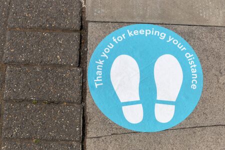 a close up view of floor, steet signage thanking poeple for the two meter distance rule during the...