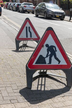 Bristol-April 2020-England-a close up view of warning road working signs on a side road の写真素材